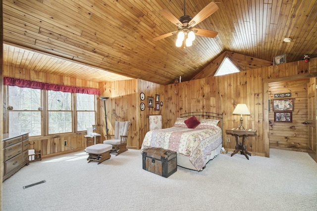 carpeted bedroom featuring visible vents, lofted ceiling, and wood walls