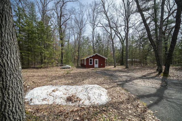 view of yard featuring an outdoor structure and a view of trees