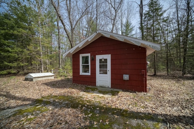 view of outbuilding with a view of trees and an outbuilding