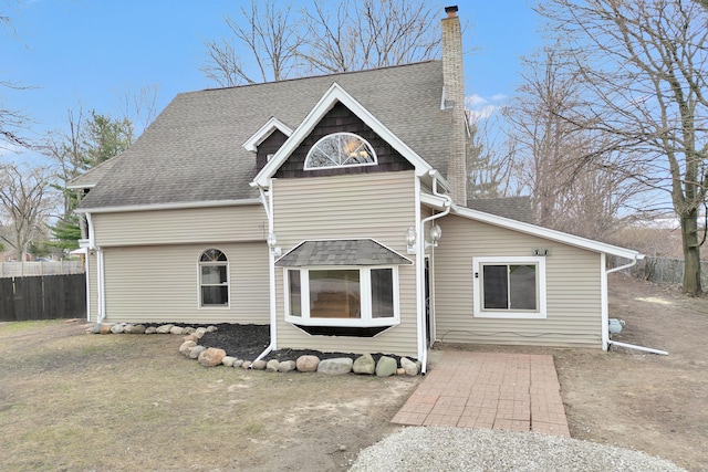 3628 Ford Ave, Jackson, MI 49203 - rear view of house featuring a chimney, fence, and a shingled roof