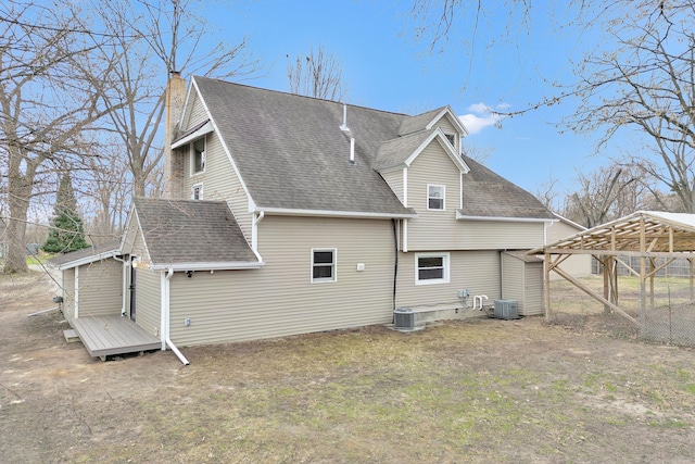 3628 Ford Ave, Jackson, MI 49203 - back of house featuring a shingled roof, a chimney, and central AC