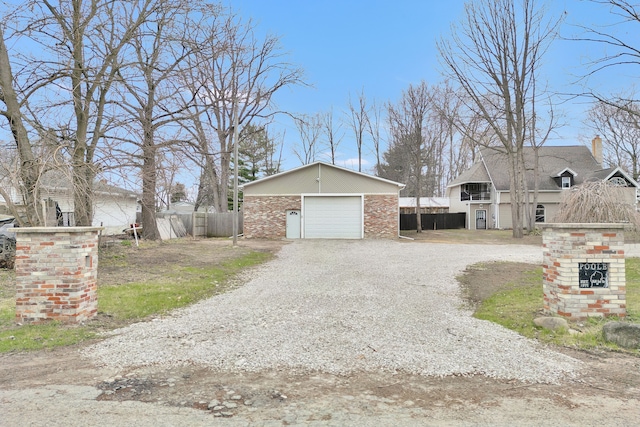 3628 Ford Ave, Jackson, MI 49203 - view of property exterior featuring gravel driveway, a chimney, fence, an outbuilding, and a garage