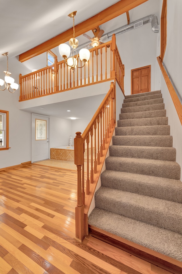 3628 Ford Ave, Jackson, MI 49203 - staircase featuring visible vents, a towering ceiling, wood finished floors, and a notable chandelier