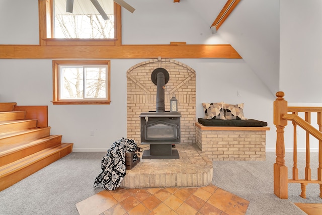 3628 Ford Ave, Jackson, MI 49203 - living area featuring beamed ceiling, carpet, a wood stove, and stairs