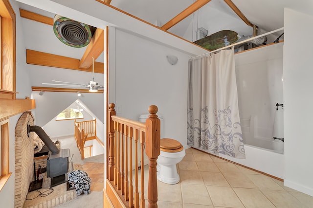 3628 Ford Ave, Jackson, MI 49203 - full bathroom featuring tile patterned floors, shower / bath combination with curtain, a wood stove, baseboards, and toilet