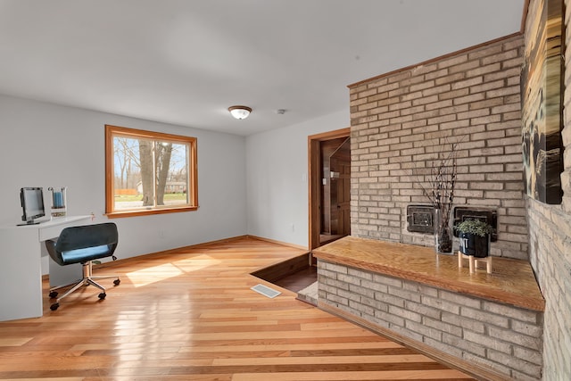 3628 Ford Ave, Jackson, MI 49203 - unfurnished office with a wood stove, wood finished floors, and visible vents