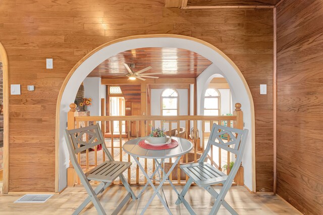 3628 Ford Ave, Jackson, MI 49203 - dining area featuring wooden walls, wood finished floors, arched walkways, and a ceiling fan