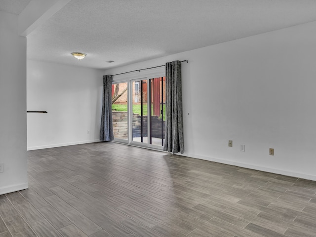 2401 Packard St Unit 31D, Ann Arbor, MI 48104 - empty room with a textured ceiling, wood finished floors, and baseboards