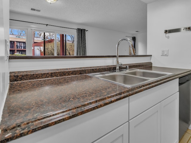 2401 Packard St Unit 31D, Ann Arbor, MI 48104 - kitchen featuring a sink, dark countertops, white cabinets, a textured ceiling, and visible vents