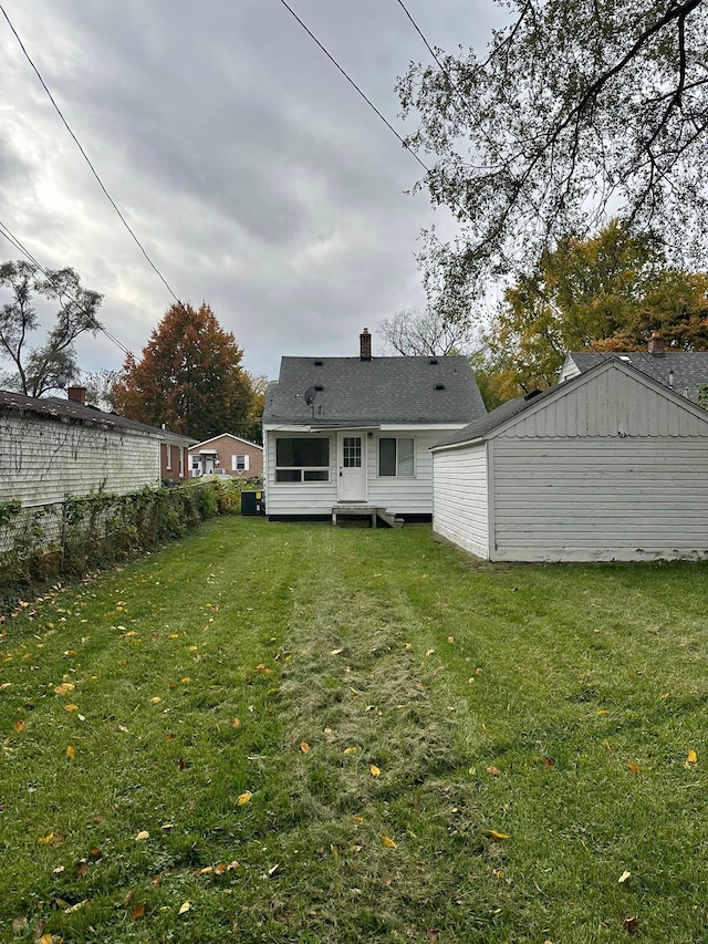 18850 Dalby, Redford, MI 48240 - back of house with a chimney, fence, and a lawn