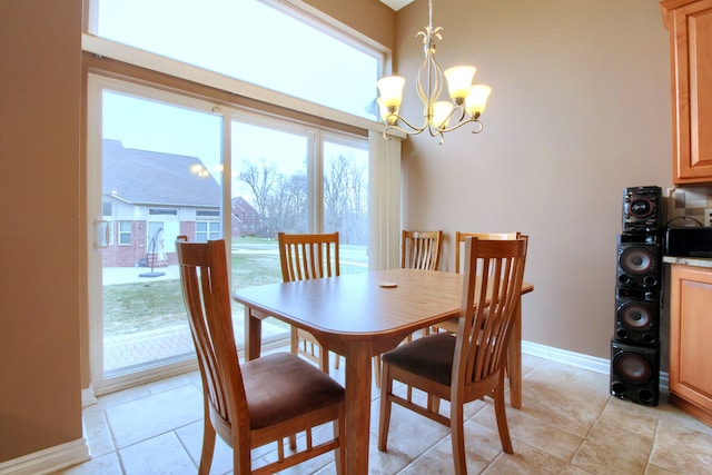 dining area with light tile patterned floors, a notable chandelier, and baseboards