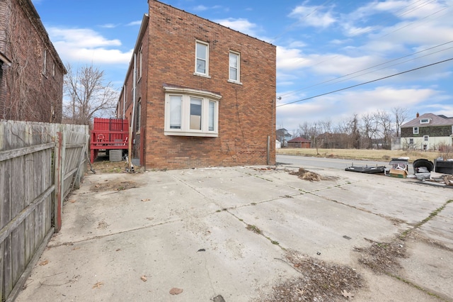 back of house with a patio, fence, and brick siding