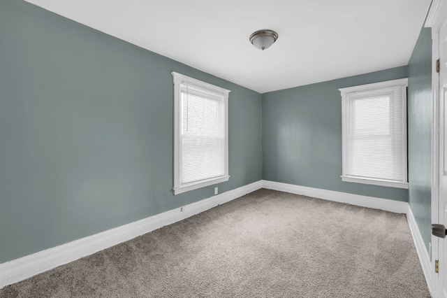 carpeted empty room with baseboards