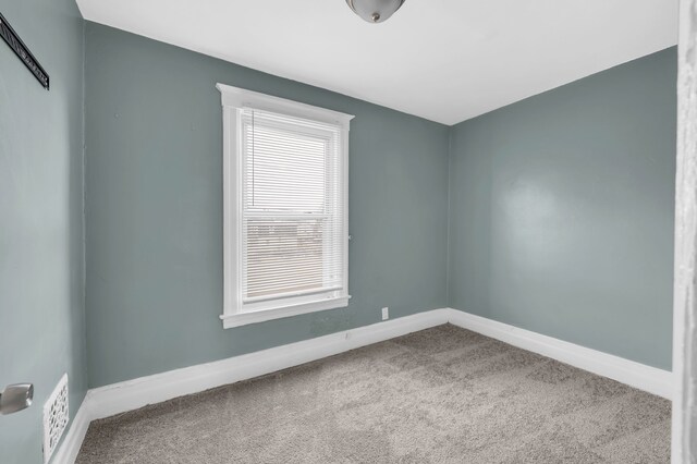 empty room featuring baseboards and carpet floors
