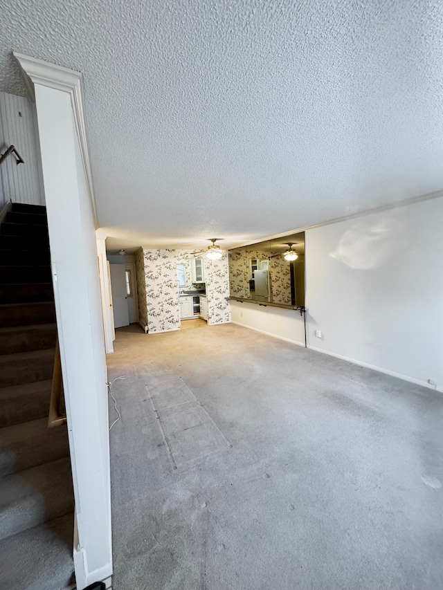 5959 Alan Dr Unit 57, Brighton, MI 48116 - unfurnished living room with a textured ceiling, baseboards, carpet floors, and stairway