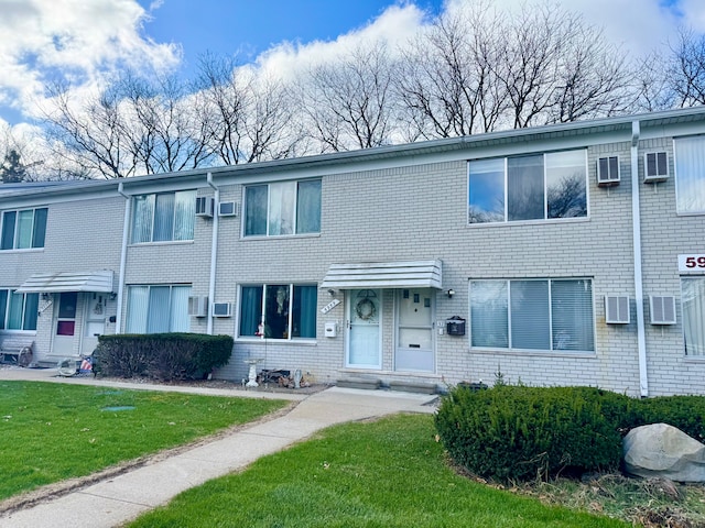 5959 Alan Dr Unit 57, Brighton, MI 48116 - multi unit property featuring brick siding, an AC wall unit, and a front lawn