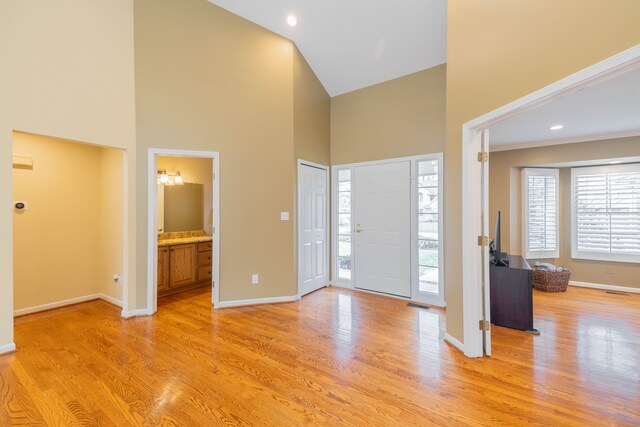 7837 Oak River Dr, Grosse Ile, MI 48138 - foyer entrance featuring baseboards, light wood-type flooring, plenty of natural light, and a high ceiling