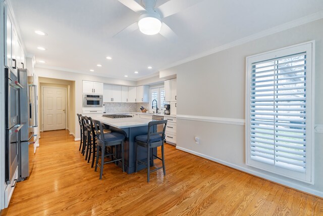 7837 Oak River Dr, Grosse Ile, MI 48138 - dining room with crown molding, light wood-style flooring, a ceiling fan, and baseboards