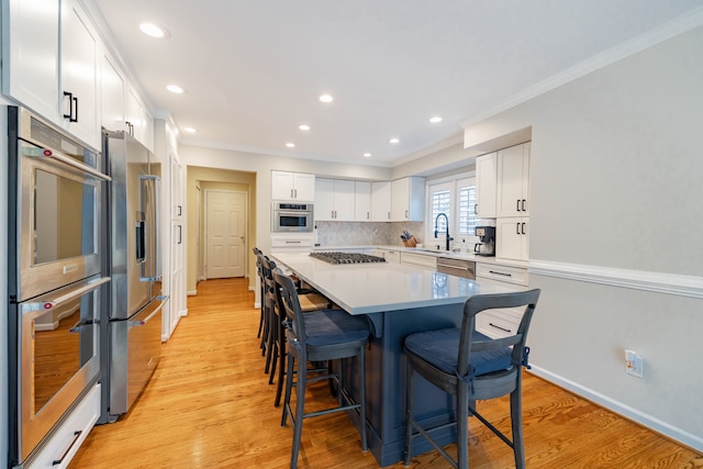7837 Oak River Dr, Grosse Ile, MI 48138 - kitchen featuring a kitchen breakfast bar, crown molding, white cabinets, stainless steel appliances, and a sink