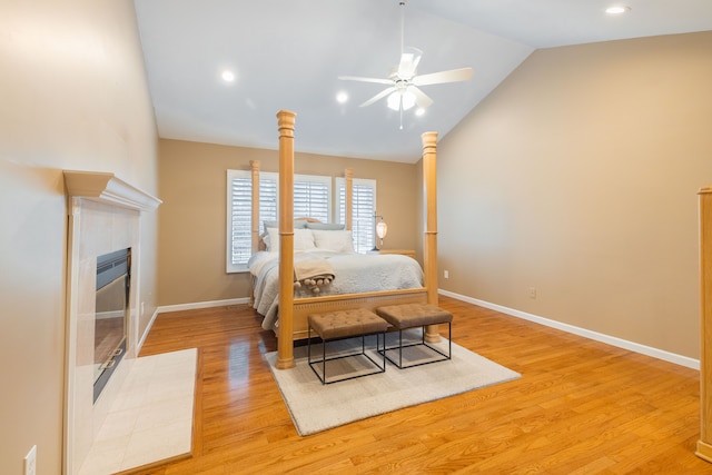 7837 Oak River Dr, Grosse Ile, MI 48138 - bedroom with light wood-style floors, a tiled fireplace, baseboards, and vaulted ceiling