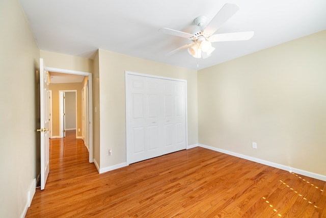 7837 Oak River Dr, Grosse Ile, MI 48138 - unfurnished bedroom with a closet, baseboards, light wood-type flooring, and ceiling fan