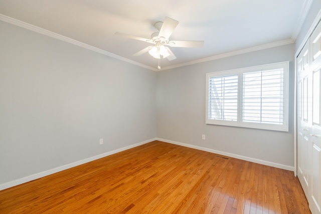 7837 Oak River Dr, Grosse Ile, MI 48138 - spare room featuring light wood-type flooring, baseboards, ornamental molding, visible vents, and ceiling fan