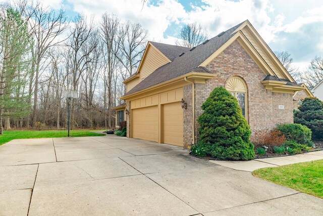 7837 Oak River Dr, Grosse Ile, MI 48138 - view of side of property with roof with shingles, concrete driveway, and brick siding