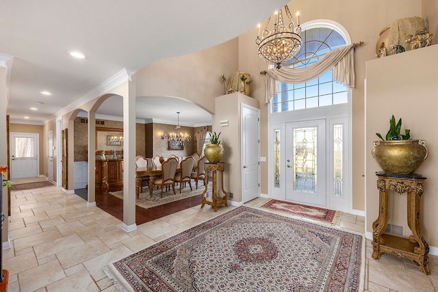 2434 Pebble Beach Dr, Oakland, MI 48363 - foyer entrance with crown molding, an inviting chandelier, arched walkways, a high ceiling, and stone tile flooring