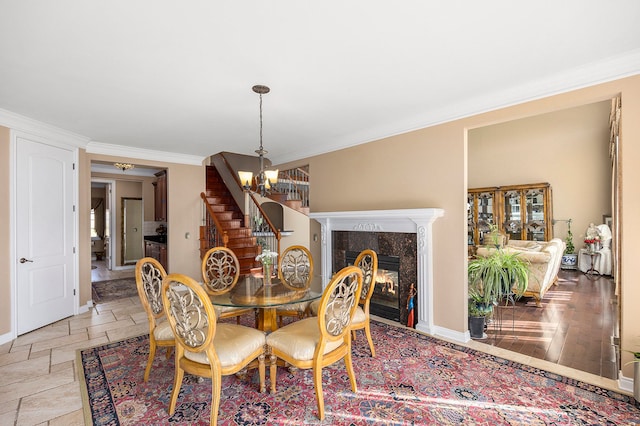 2434 Pebble Beach Dr, Oakland, MI 48363 - dining area featuring baseboards, an inviting chandelier, stone tile flooring, crown molding, and stairs