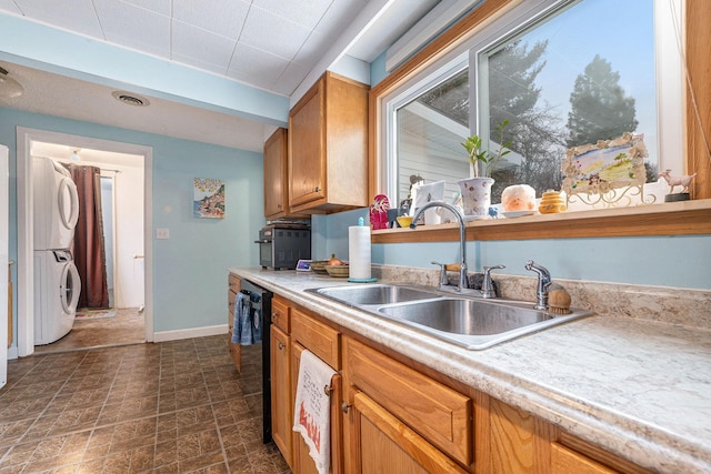 kitchen with stacked washer / dryer, dishwasher, a sink, and light countertops