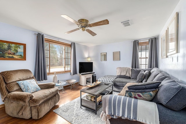 living room with visible vents, a ceiling fan, and wood finished floors
