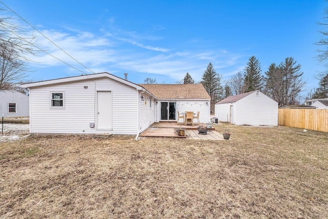 rear view of house featuring an outdoor structure, a patio area, an outdoor fire pit, fence, and a lawn