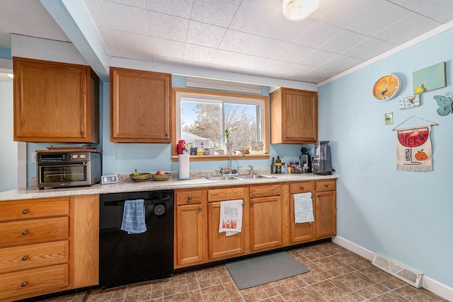 kitchen with visible vents, baseboards, black dishwasher, a sink, and light countertops