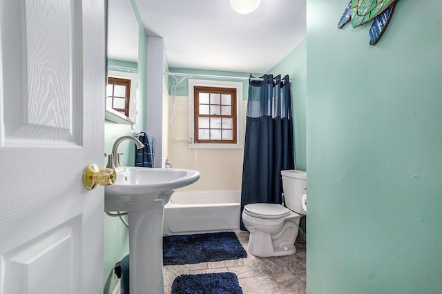 full bath featuring shower / tub combo with curtain, a sink, and toilet