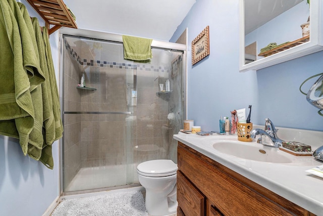 bathroom featuring toilet, a shower stall, and vanity