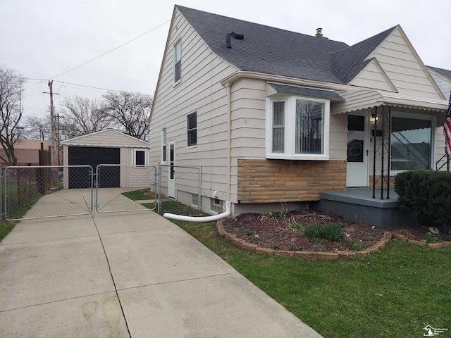 3857 14th St, Wyandotte, MI 48192 - view of front of home featuring a gate, a detached garage, an outbuilding, fence, and a shingled roof