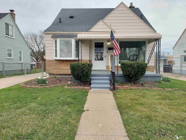 3857 14th St, Wyandotte, MI 48192 - bungalow featuring a front lawn, fence, stone siding, and a shingled roof