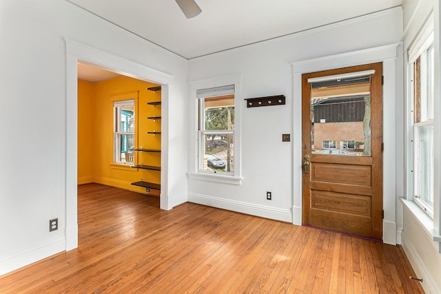 foyer with light wood-type flooring, baseboards, and a ceiling fan