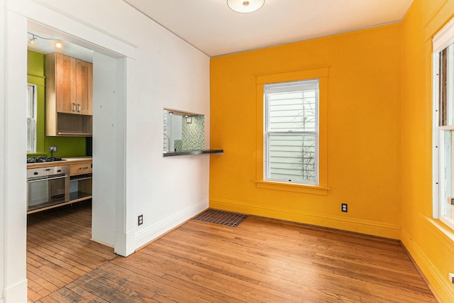 spare room with light wood-style flooring and baseboards