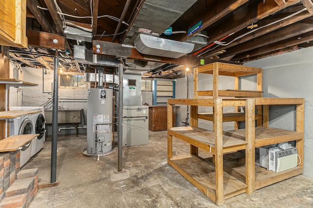 unfinished basement with heating unit, gas water heater, and washer and clothes dryer