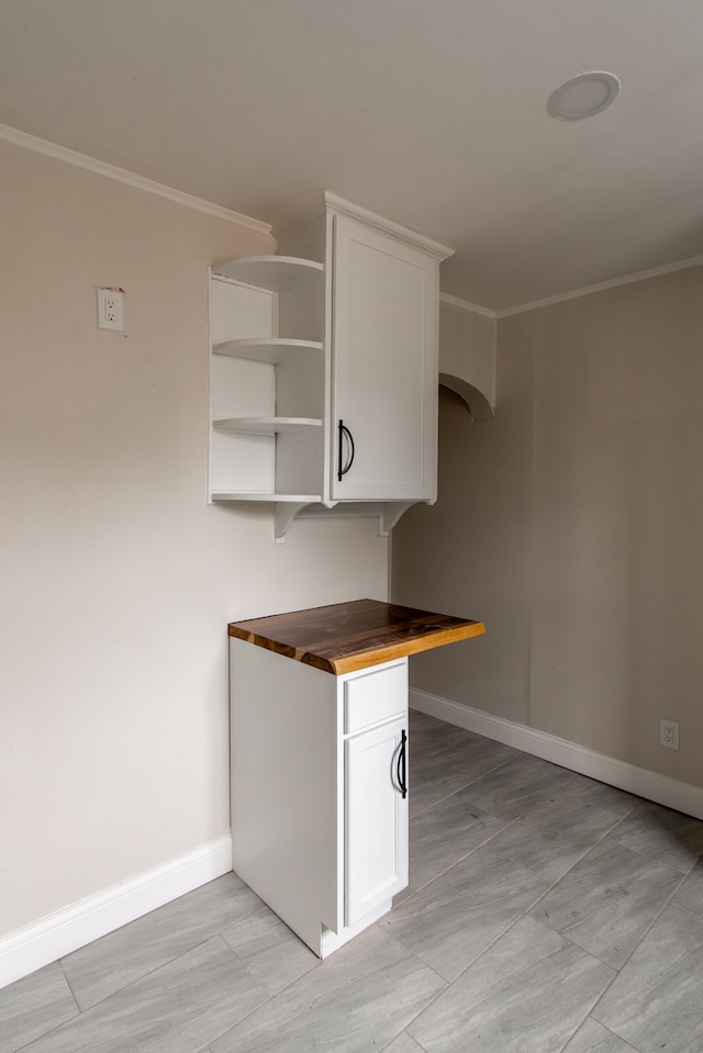 9661 Asbury Park, Detroit, MI 48227 - kitchen featuring butcher block counters, ornamental molding, open shelves, white cabinets, and baseboards