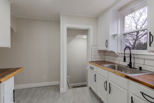9661 Asbury Park, Detroit, MI 48227 - kitchen with butcher block counters, baseboards, a sink, and backsplash