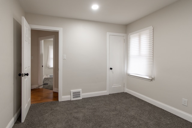 9661 Asbury Park, Detroit, MI 48227 - unfurnished bedroom with visible vents, baseboards, and dark carpet