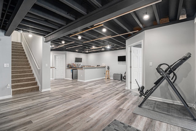 4117 Avery Rd, Lake Orion, MI 48359 - finished below grade area with light wood-style floors, stairs, baseboards, and bar