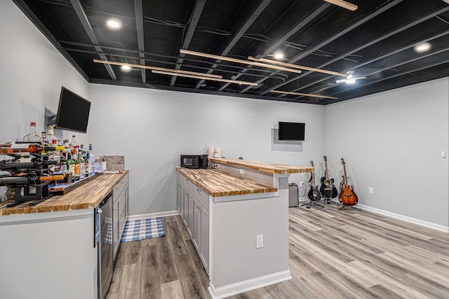 4117 Avery Rd, Lake Orion, MI 48359 - bar with baseboards, black microwave, bar, and light wood finished floors