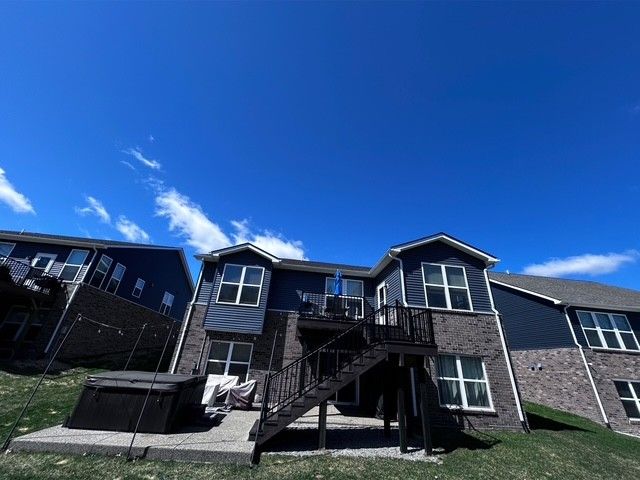 4117 Avery Rd, Lake Orion, MI 48359 - back of property featuring a deck, a patio, brick siding, stairs, and a hot tub