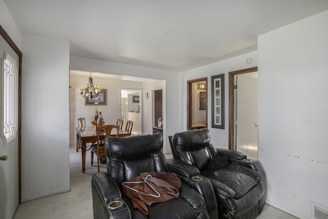 living room with visible vents, light wood-style flooring, and an inviting chandelier