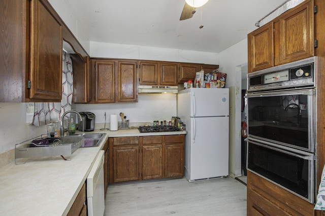 kitchen with a ceiling fan, black appliances, under cabinet range hood, a sink, and light countertops