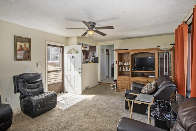 living room with a textured ceiling, ceiling fan, and carpet floors