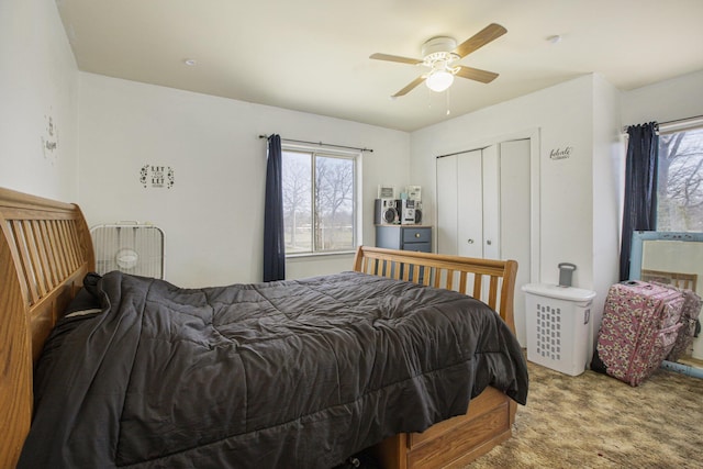 bedroom with a closet, multiple windows, a ceiling fan, and carpet floors